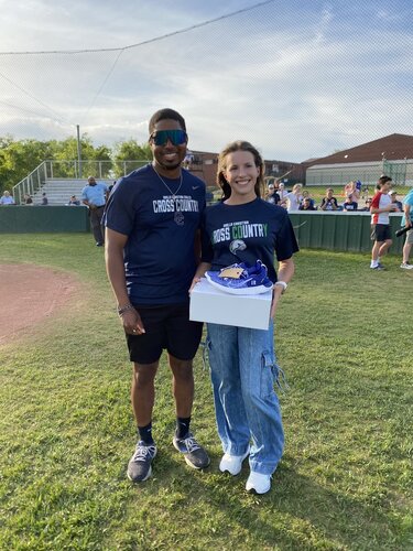 Emma Rhodes 2024 cross country state champion, is presented with a pair of custom running shoes.
Ian white