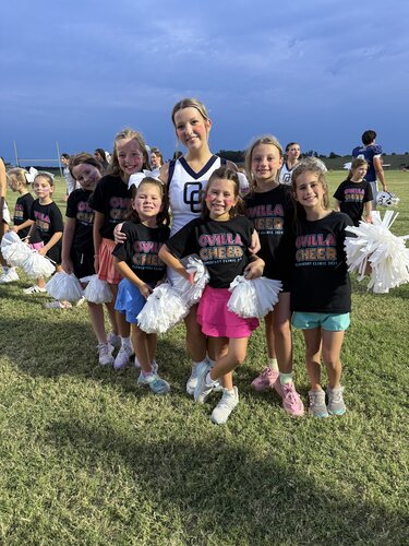 Varsity cheerleaders helping elementary cheerleaders during the football game