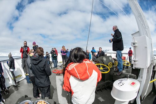 DNYHC3 Polar Pioneer Afternoon Tea Fournier Bay Antarctica // Passengers and crew gather for outdoor afternoon tea on the deck of the Polar Pioneer in Fournier Bay in Antarctica. The Polar Pioneer is a Russian ice-strengthened ship operated by Australian company Aurora Expeditions.