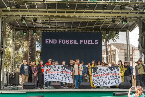 Activists gather on the Santa Barbara Earth Day Festival Mainstage for a call to action around phasing out harmful fossil fuels and holding polluters accountable.