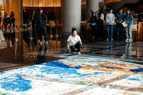 Astana, Kazakhstan — Kazakh artist Alina Akhmetbek presents 72 Voices of Earth, a monumental large-scale quilling mosaic that merges paper art, environmental symbolism,  and conceptual storytelling into a single immersive artwork. The project was publicly demonstrated on April 22, 2026, in celebration of Earth Day, as a World Guinness Records attempt to create the largest paper quilling mosaic image of Earth.
Measuring 41.66 square meters, the artwork consists of 72 individual pieces and more than 300 hundred thousands of individually hand-rolled paper elements arranged into a highly detailed representation of Earth. Entirely handmade over the course of six years, every quill was rolled by hand and carefully applied onto wooden boards to create the final mosaic. 

The mosaic is structured through two interconnected conceptual systems: the symbolism of the number 72 and the geometry of the logarithmic spiral.